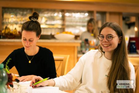 Zwei lächelnde Frauen an einem Tisch