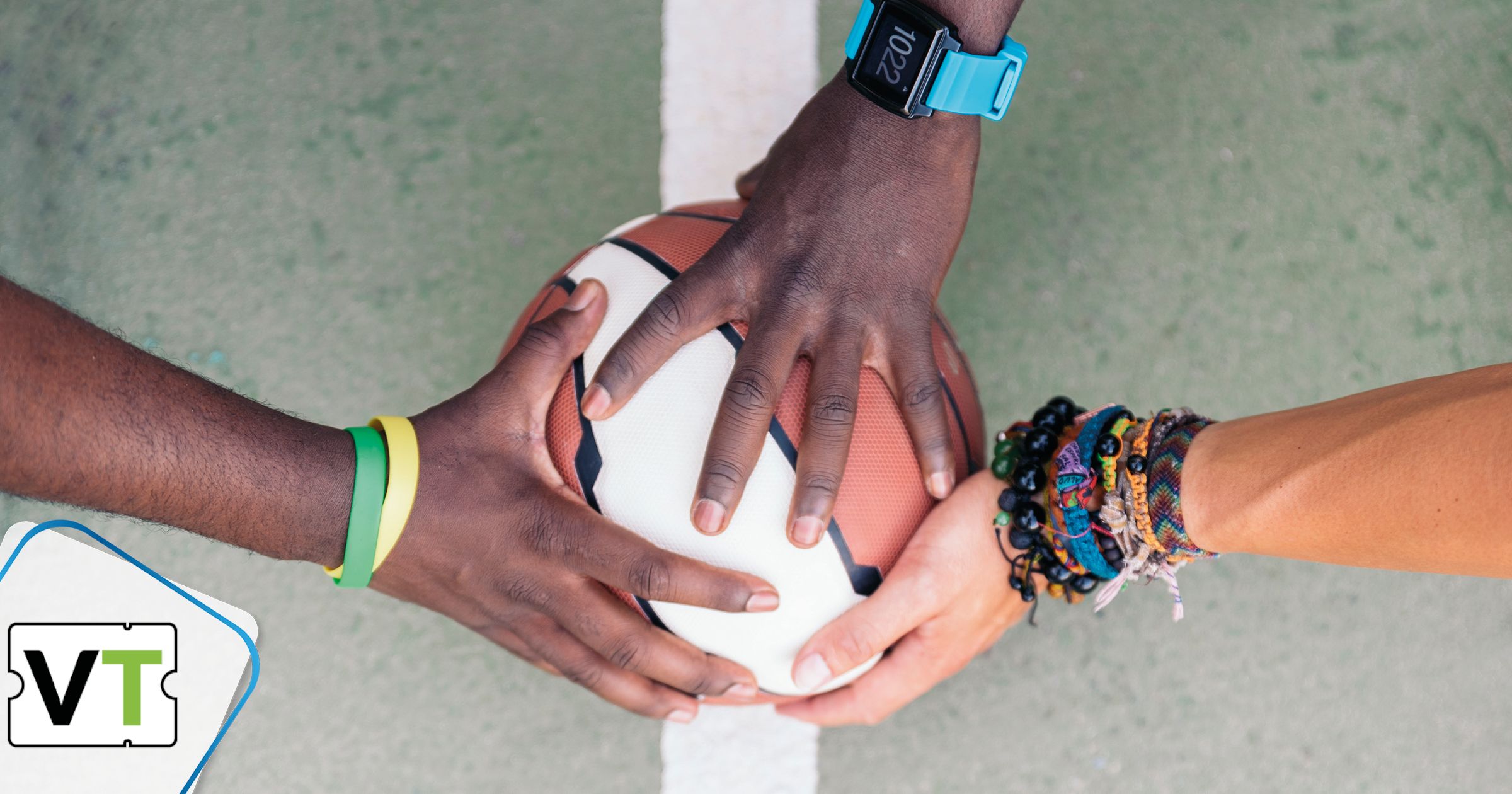 Hände von Personen unterschiedlicher Hautfarbe halten Ball