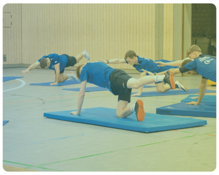 Sportler:innen bei indoor Workout auf Matten