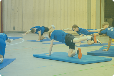 Sportler:innen bei indoor Workout auf Matten
