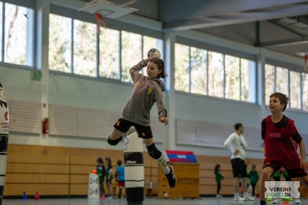 Kind macht Sprungwurf aufs Handballtor