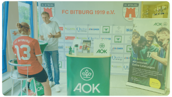 AOK Stand, Mitarbeiter im Gespräch mit Sportlerin